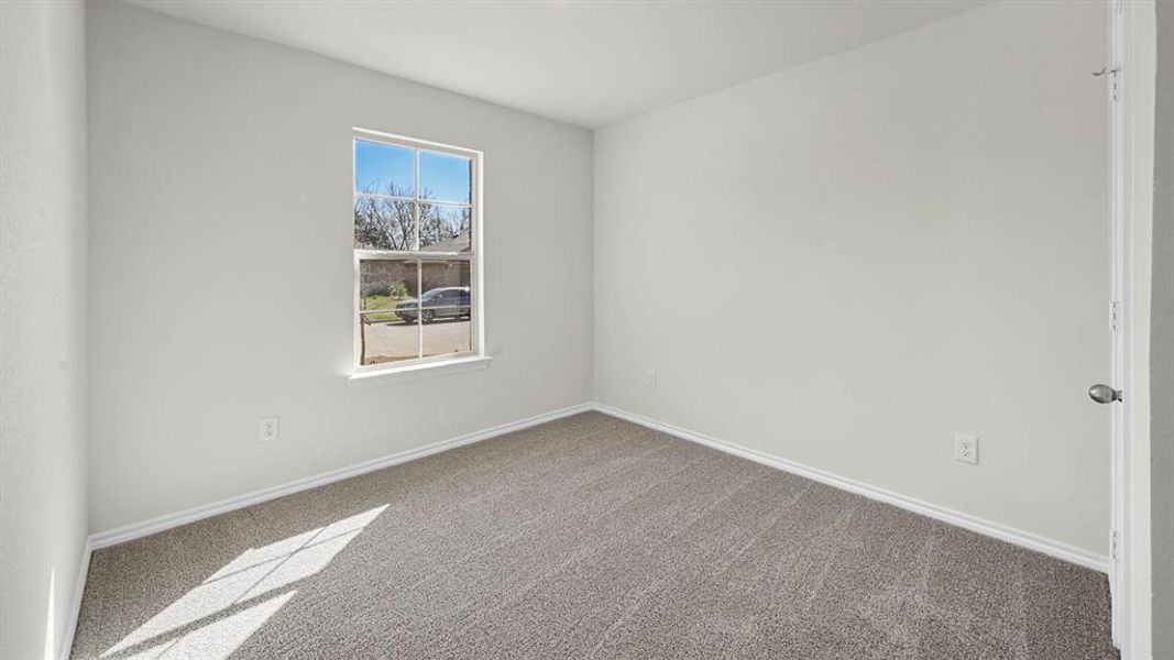 Carpeted spare room featuring baseboards