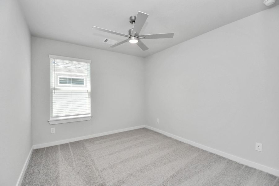 Secondary bedroom features plush carpeting, large windows that let in plenty of natural light, bright paint, and spacious closets.