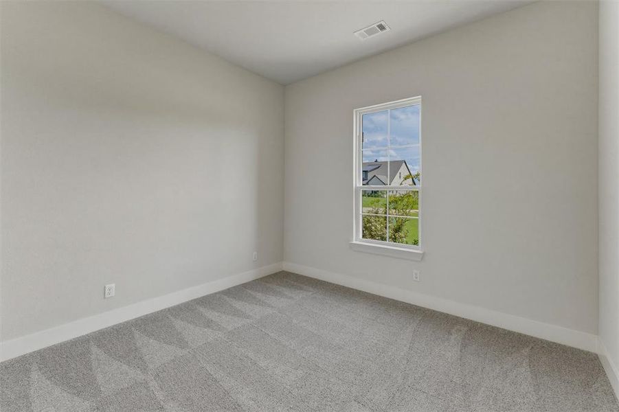 Neutral-toned room featuring a single window with white trim, light gray walls, and geometric pattern carpet Neutral-toned room featuring a single window with white trim, light gray walls, and geometric pattern carpet