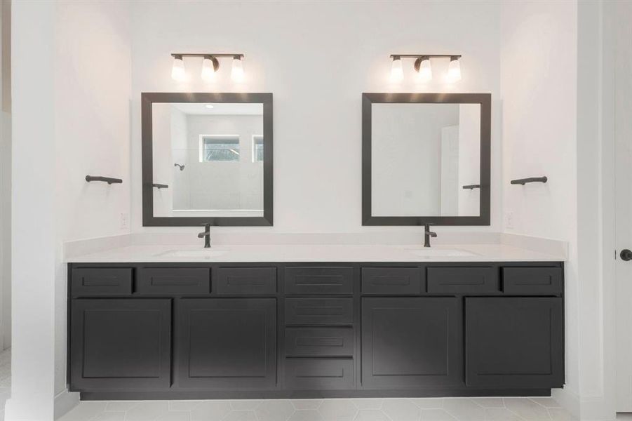 Dual vanity featuring dark cabinetry, white countertops, rectangular undermount sinks, and matte black fixtures Dual vanity featuring dark cabinetry, white countertops, rectangular undermount sinks, and matte black fixtures