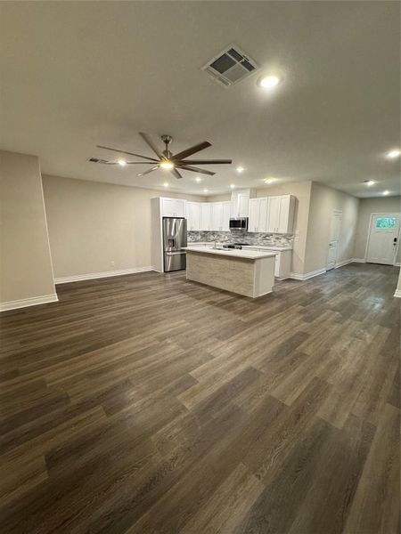 family room open to the kitchen. Vinyl plank flooring all down stairs