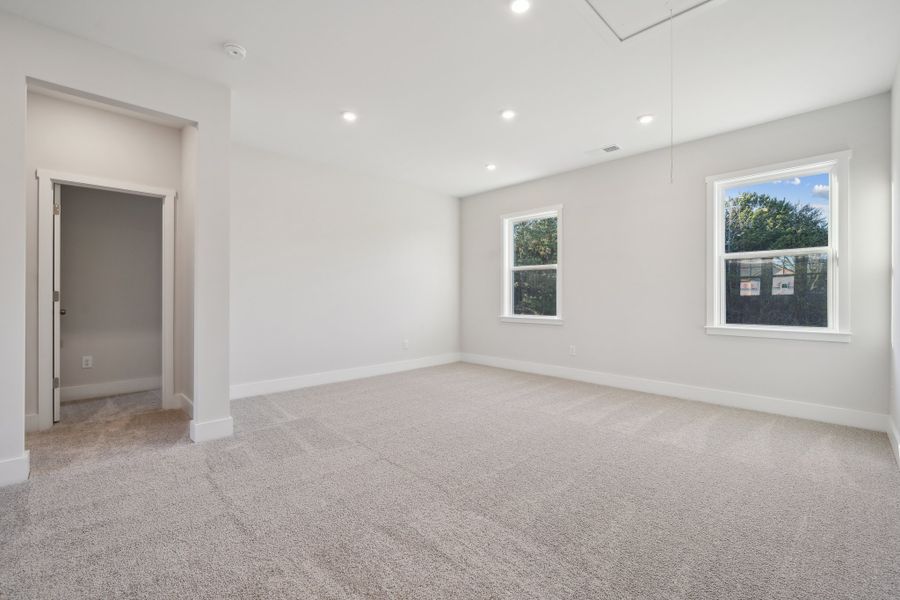 A room with a carpet and windows.