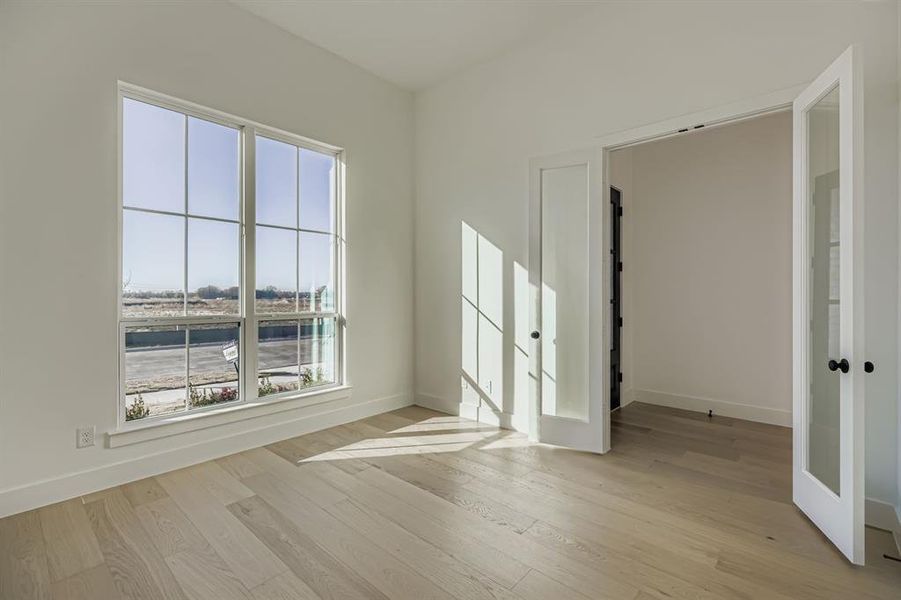 Spare room with light wood-type flooring and french doors