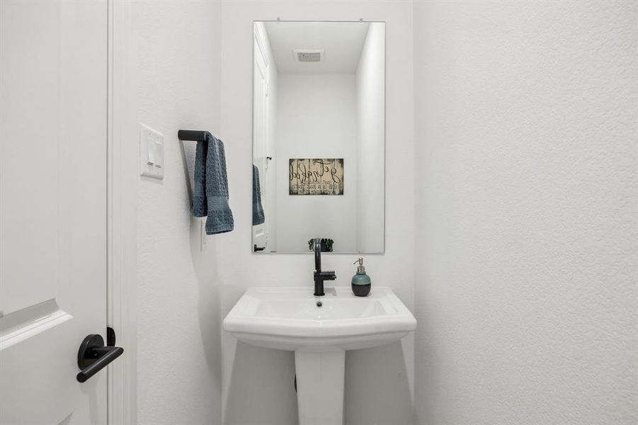 Pedestal sink with black faucet hardware and a rectangular mirror Pedestal sink with black faucet hardware and a rectangular mirror