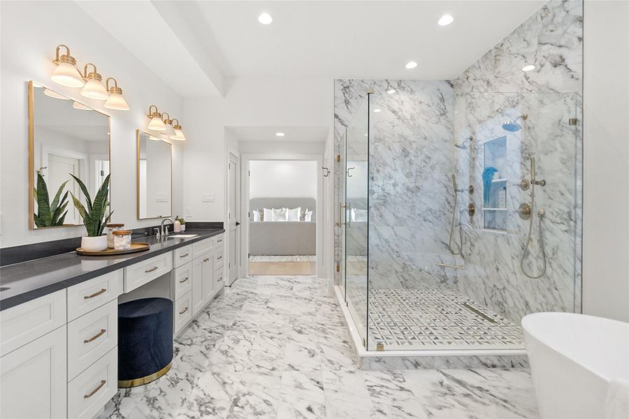 This expansive primary bathroom gives you a true spa-at-home experience, with dual vanities, warm brass lighting, and a seamless flow into the oversized glass-enclosed marble shower. The clean lines, designer finishes, and abundant lighting make your morning and nighttime routines feel calm, elevated, and effortlessly organized.