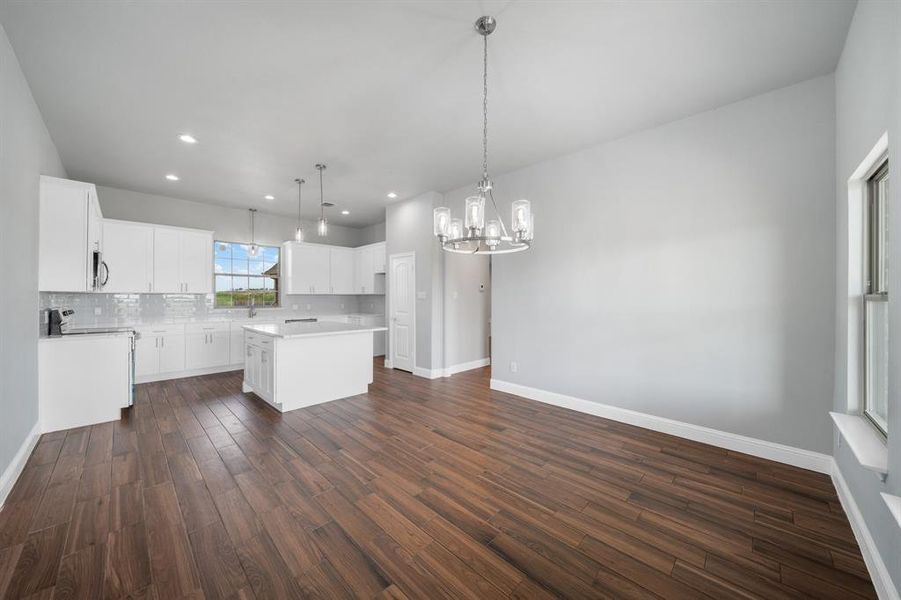 Kitchen with a kitchen island, dark wood-type flooring, and pendant lighting