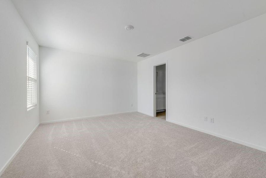 Spare room featuring light colored carpet and baseboards