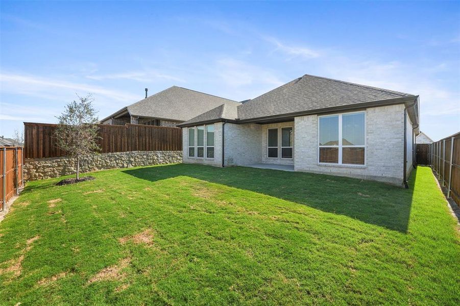 Back of property featuring a yard and a patio area