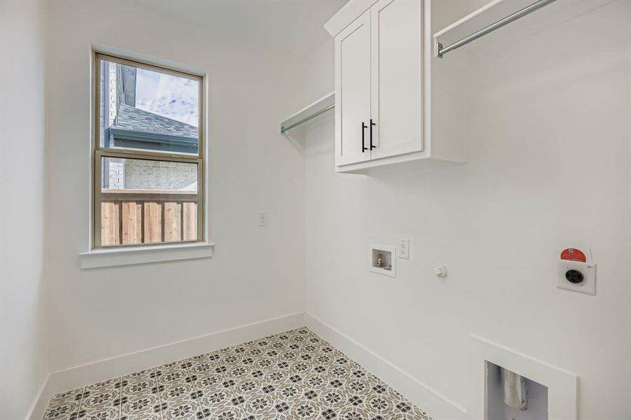 Washroom with hookup for a gas dryer, hookup for a washing machine, cabinet space, and hookup for an electric dryer Washroom with hookup for a gas dryer, hookup for a washing machine, cabinet space, and hookup for an electric dryer