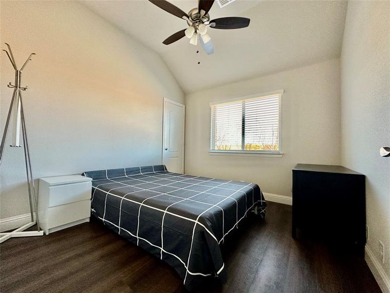 Bedroom with ceiling fan, vaulted ceiling, and wood-type flooring