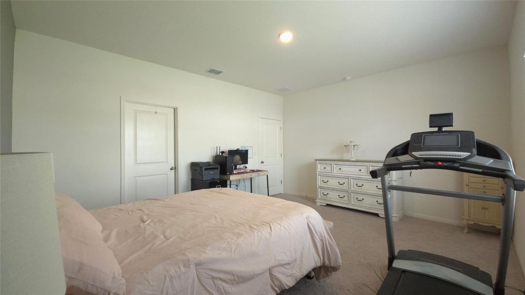 Carpeted room with a vaulted ceiling, recessed lighting, and two panel doors