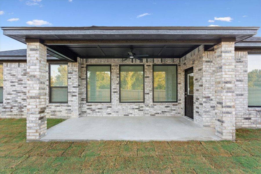 Property entrance featuring a patio area, ceiling fan, and brick siding Property entrance featuring a patio area, ceiling fan, and brick siding