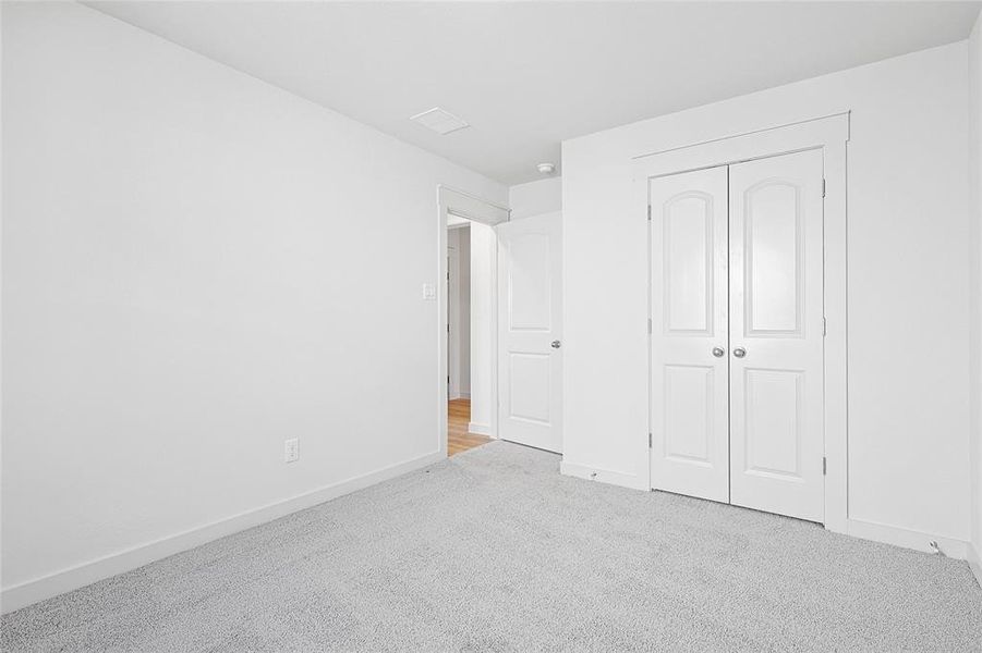 Unfurnished bedroom featuring light colored carpet and a closet