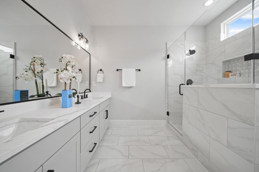 The primary bath showcases elegant 12”x 24” marble ceramic tile floors. The primary bath showcases elegant 12”x 24” marble ceramic tile floors.