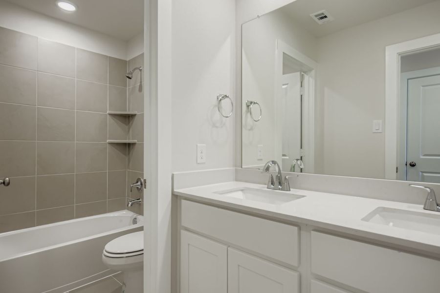 A bathroom with a tub sink and toilet.