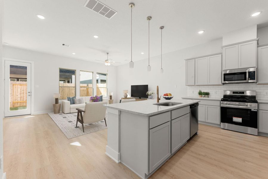 This open-concept kitchen and living space blends modern design with comfort. The kitchen showcases soft gray cabinetry, quartz countertops, stainless steel appliances, and a spacious island with pendant lighting. Large windows fill the area with natural light, creating a bright and welcoming atmosphere that flows seamlessly into the living room. This open-concept kitchen and living space blends modern design with comfort. The kitchen showcases soft gray cabinetry, quartz countertops, stainless steel appliances, and a spacious island with pendant lighting. Large windows fill the area with natural light, creating a bright and welcoming atmosphere that flows seamlessly into the living room.