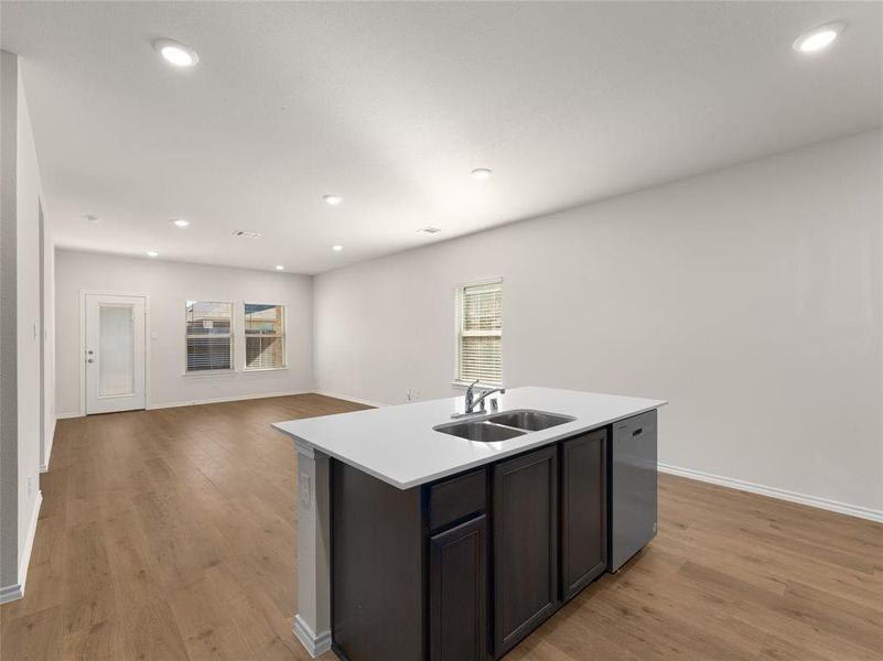 Kitchen with dishwasher, an island with sink, plenty of natural light, and sink