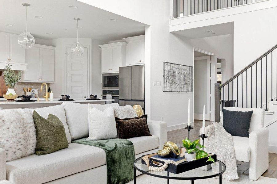 An open-concept living area boasts high ceilings and seamless flow to a well-appointed kitchen.