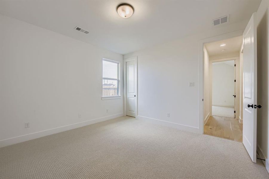 Unfurnished bedroom with light carpet and baseboards Unfurnished bedroom with light carpet and baseboards