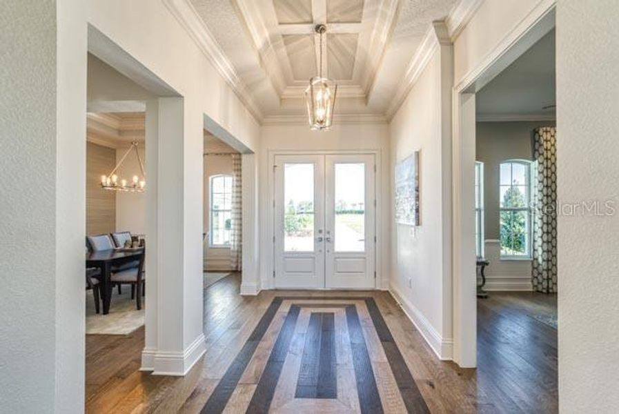 Foyer with Beautiful Wood Floor and Coffered Ceiling with Crown Molding