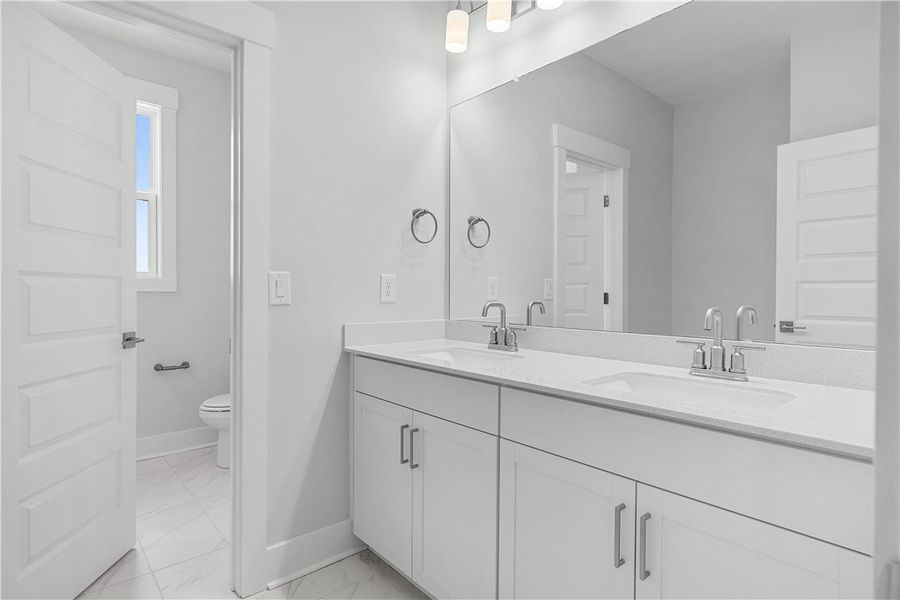 Modern double vanity with white cabinetry and slee Modern double vanity with white cabinetry and slee