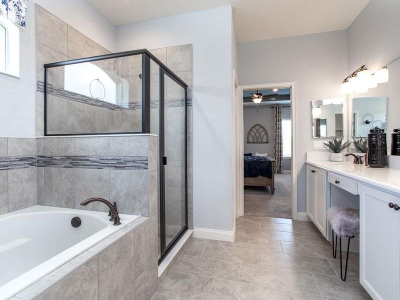 Luxurious en-suite owner`s bath with garden tub, tiled shower, dual vanities with sitting area, large walk-in wardrobe, and enclosed toilet - Westin ll home plan by Highland Homes