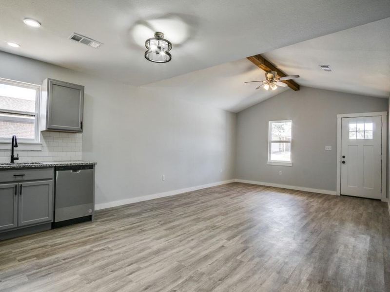 Unfurnished dining area featuring ceiling fan, sink, light hardwood / wood-style flooring, and vaulted ceiling with beams Unfurnished dining area featuring ceiling fan, sink, light hardwood / wood-style flooring, and vaulted ceiling with beams