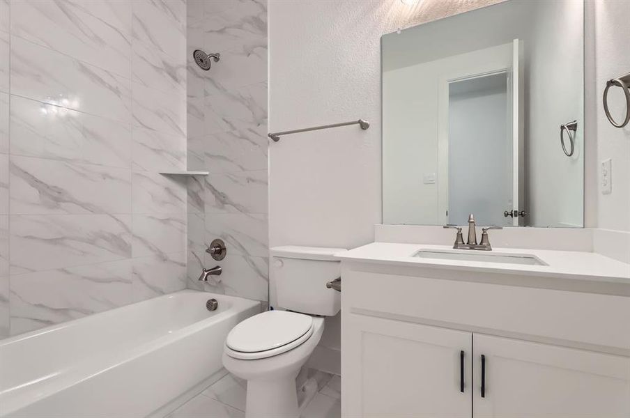 Full bathroom with vanity, toilet, and tiled shower / bath