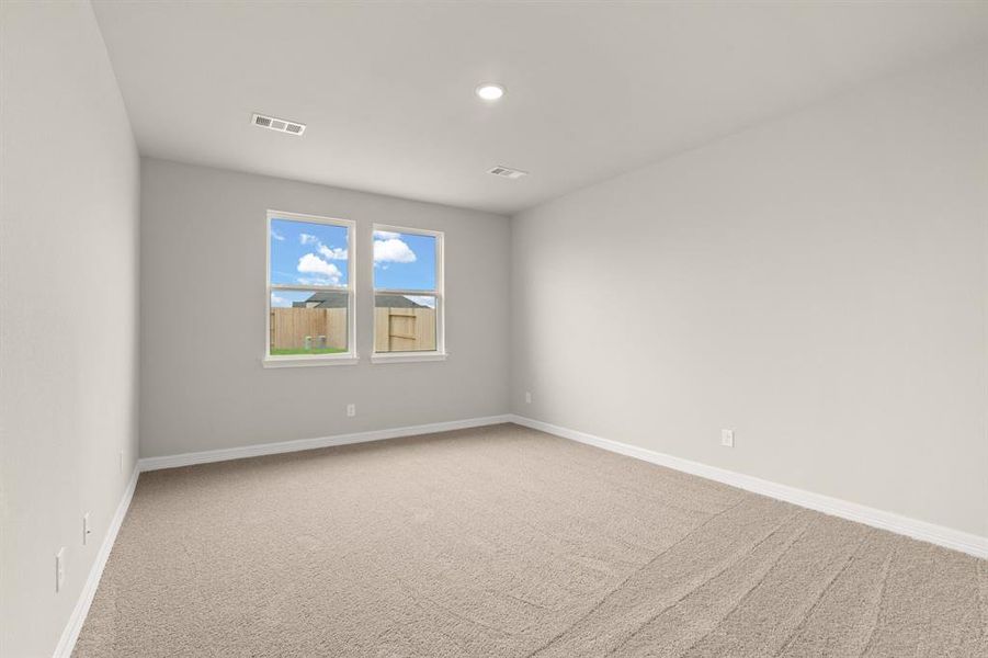 The primary bedroom is generously sized, creating a tranquil and spacious retreat that offers ample room for relaxation. Featuring plush carpet, high ceilings, fresh paint, and large windows that lets in natural lighting throughout the day.