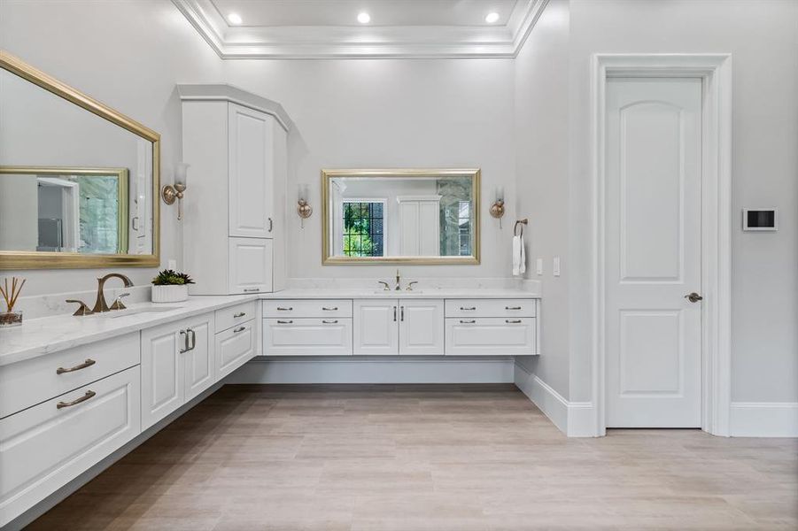 Bathroom featuring a raised ceiling, wood-type flooring, ornamental molding, and vanity