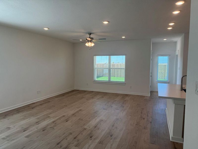 Unfurnished living room featuring recessed lighting, healthy amount of natural light, light wood finished floors, and ceiling fan Unfurnished living room featuring recessed lighting, healthy amount of natural light, light wood finished floors, and ceiling fan