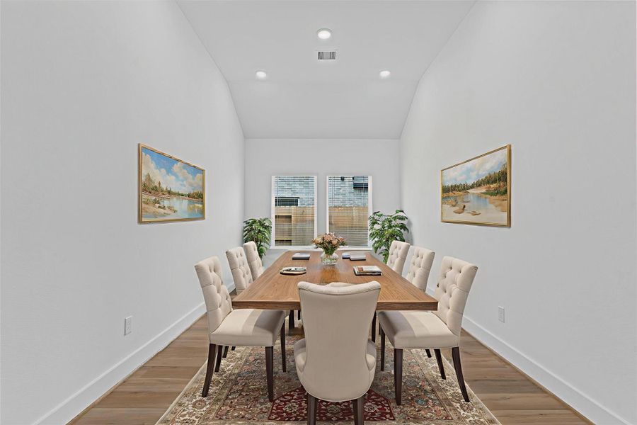 Formal dining area with tall, vaulted ceilings and clean architectural lines provides an elegant space for holiday gatherings or intimate dinners—bathed in light from the rear windows. *Virtually Staged* **Image Representative of Plan Only and May Vary as Built**.