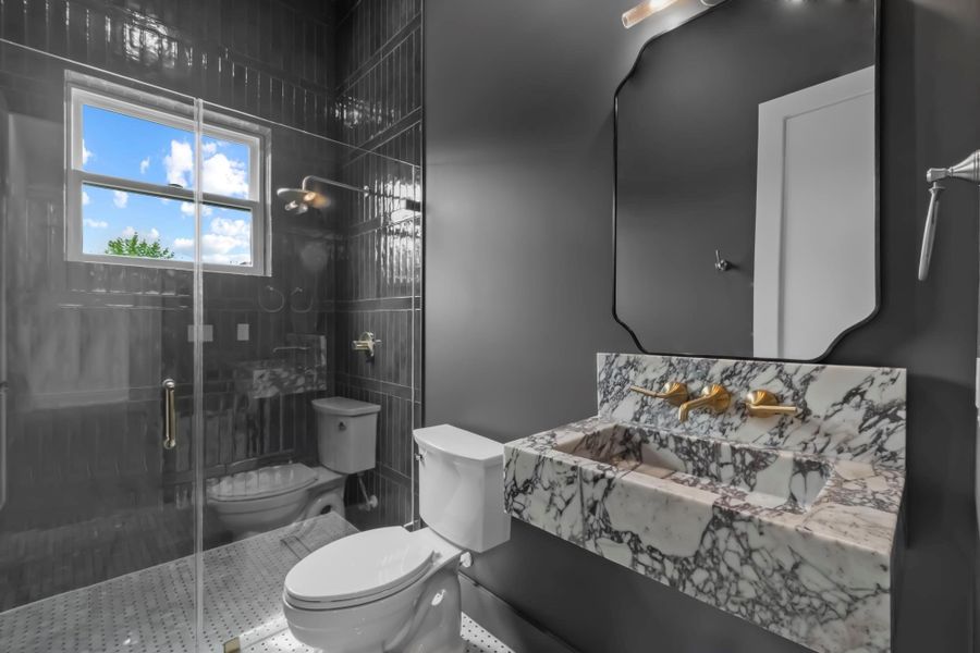 Powder bath featuring a walk-in shower and beautiful Calacatta Viola marble sink. Powder bath featuring a walk-in shower and beautiful Calacatta Viola marble sink.