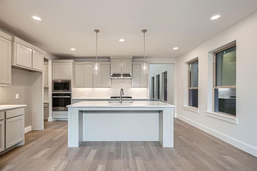 Kitchen with light countertops, stainless steel appliances, backsplash, and recessed lighting