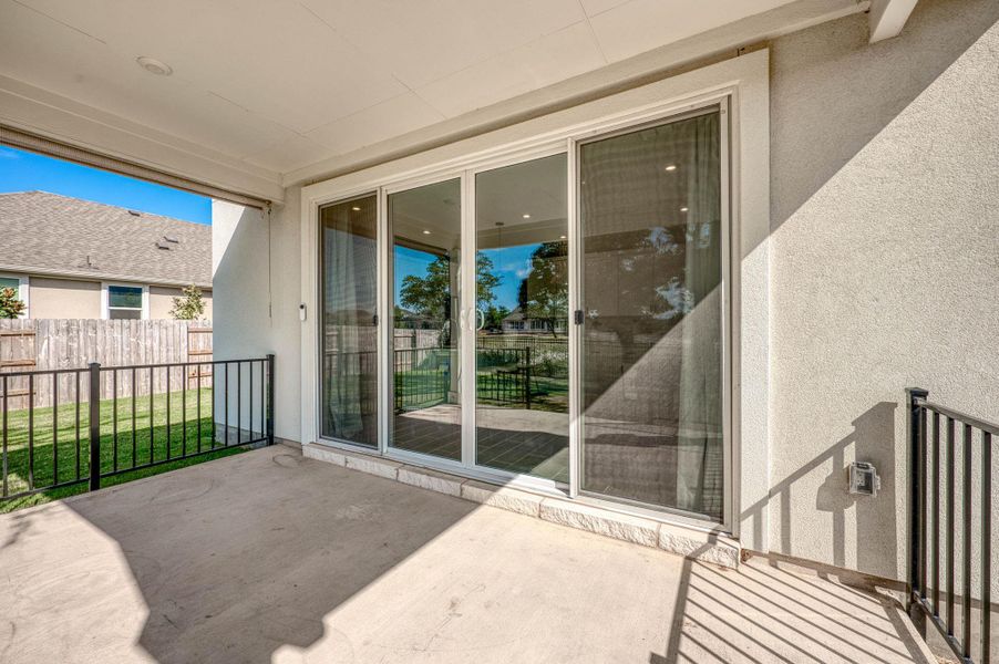 Sliding glass doors open directly to a covered concrete patio overlooking the yard. Sliding glass doors open directly to a covered concrete patio overlooking the yard.