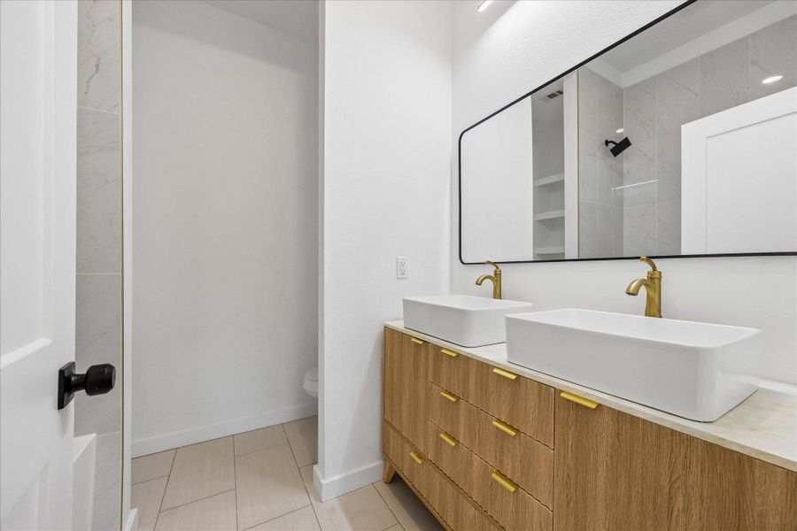 Double vanity with vessel sinks provides elegant and practical bathroom functionality.