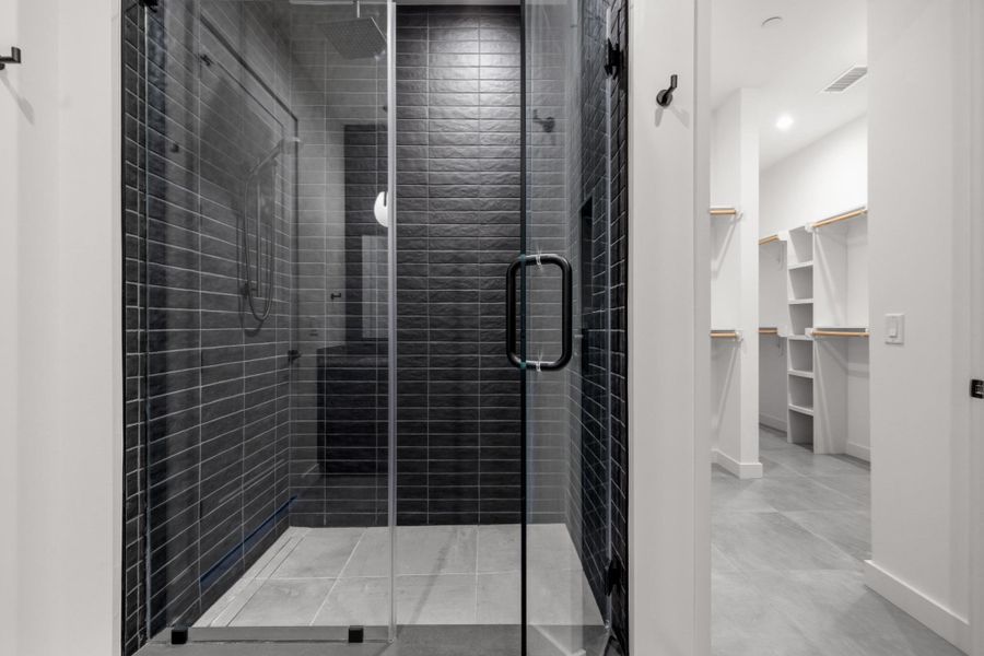 Primary Bath with spacious double vanity, floor to ceiling tile, private water closet, and a walk in shower