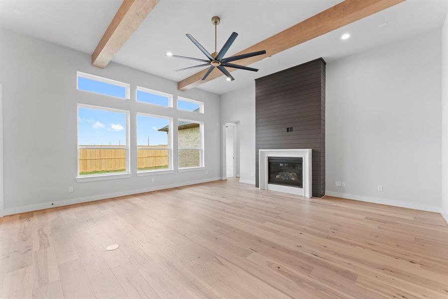 Family Room with Gas Fireplace, Beams, and Floor Outlet.