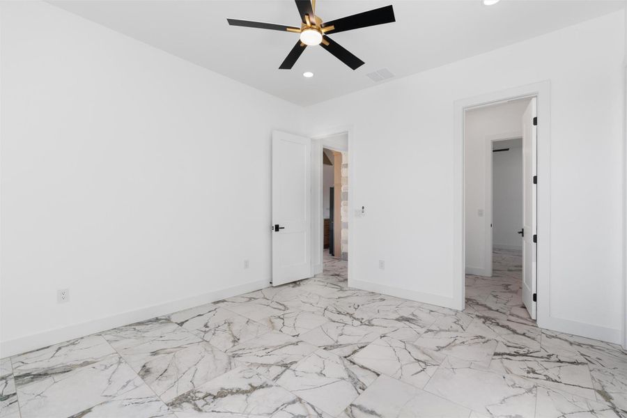 Unfurnished bedroom with ceiling fan, light marble finish flooring, and recessed lighting