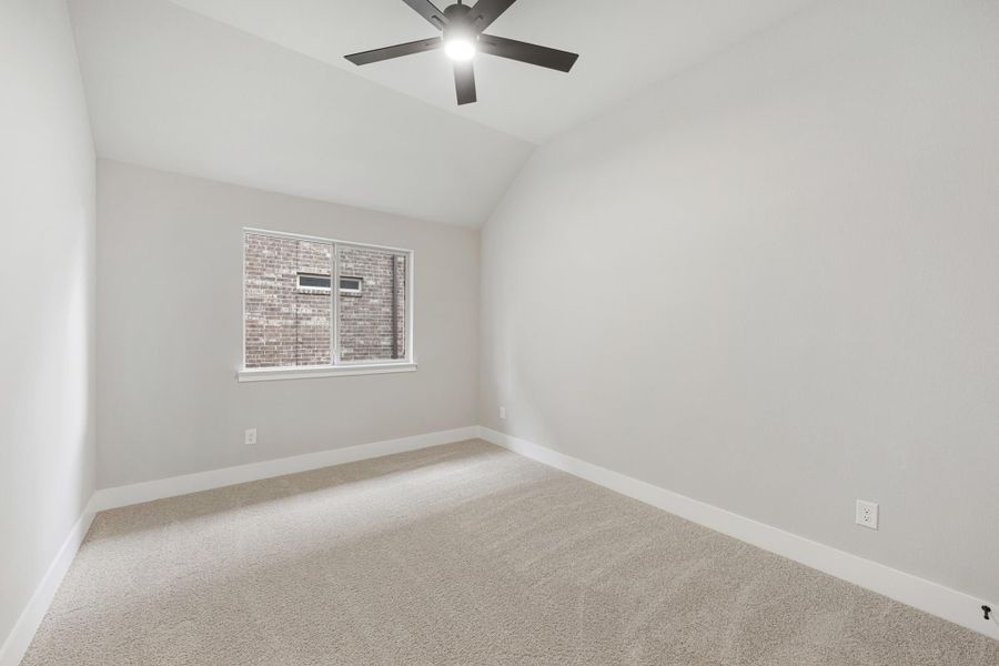 Empty bedroom with vaulted ceiling, ceiling fan, carpet flooring, and single window