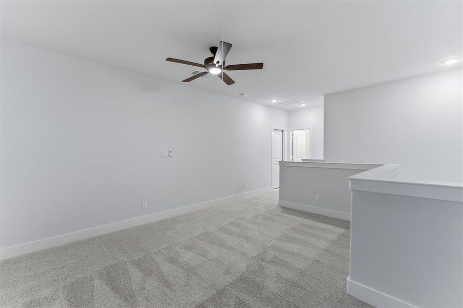 Empty room with light colored carpet, ceiling fan, and recessed lighting