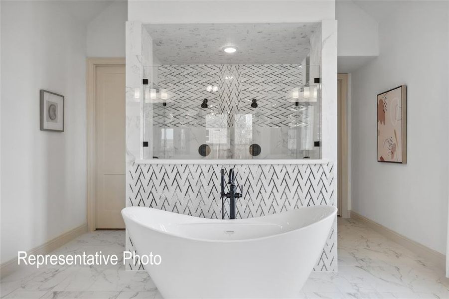 Freestanding soaking tub with black fixture, set against a striking tiled wall with a chevron pattern