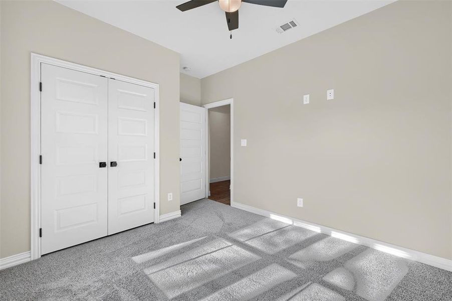 Unfurnished bedroom with carpet flooring, a closet, and ceiling fan