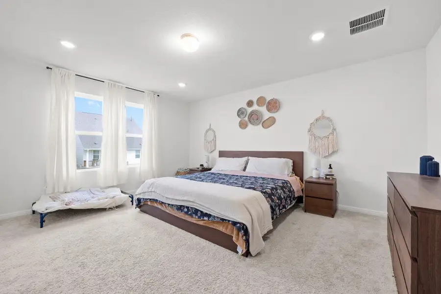 Bedroom featuring light-colored carpeting and white walls