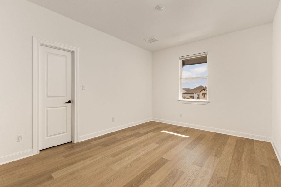Neutral interior room featuring light wood-finish flooring, white baseboards, and bright white walls