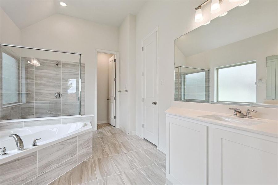 Bathroom featuring lofted ceiling, vanity, separate shower and tub, and tile patterned flooring