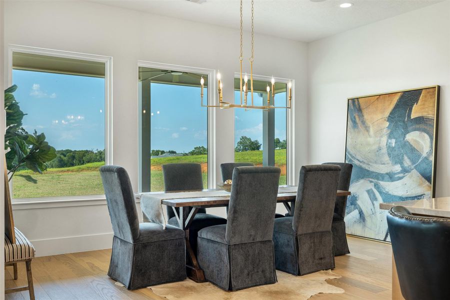 Dining area with a chandelier, light wood-type flooring, and recessed lighting