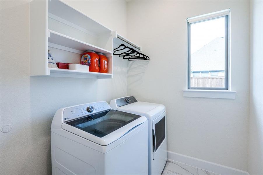 Laundry room with washing machine and dryer and baseboards Laundry room with washing machine and dryer and baseboards