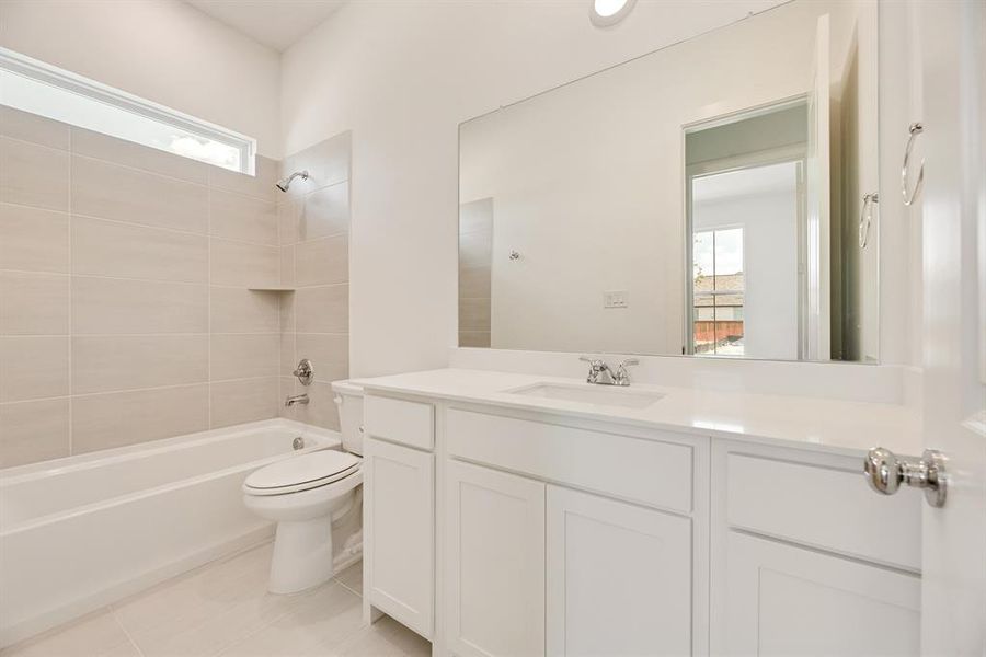 Bathroom featuring healthy amount of natural light, shower / washtub combination, vanity, and light tile patterned floors Bathroom featuring healthy amount of natural light, shower / washtub combination, vanity, and light tile patterned floors