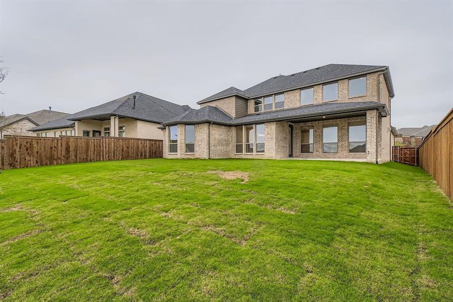 Back of house featuring brick siding, a fenced backyard, and a patio Back of house featuring brick siding, a fenced backyard, and a patio
